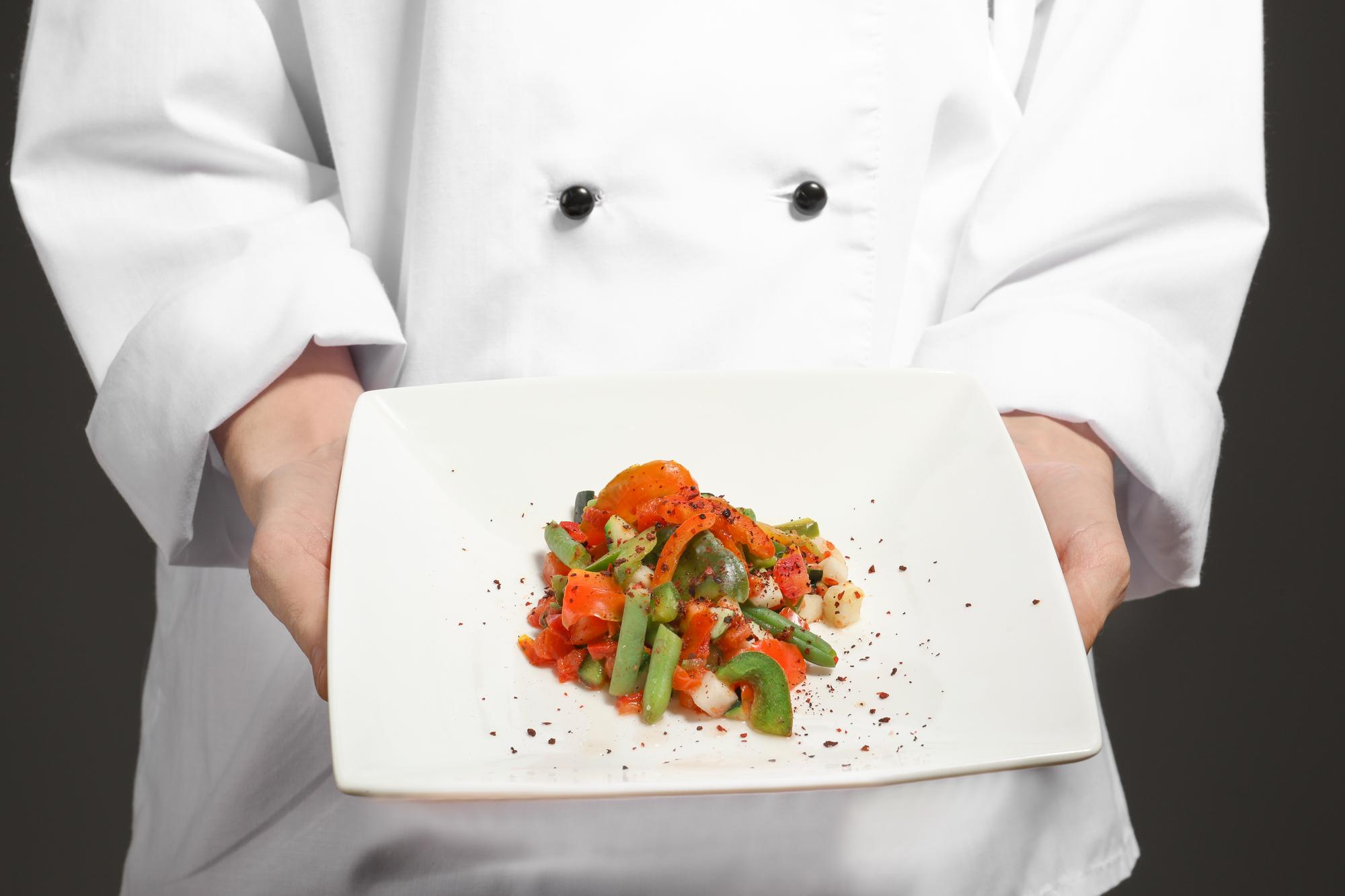 Chef plating modern dish in studio